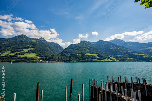Wooden poles at the small port of Quentin at lake Walensee in the Swiss Alps. Sunny spring day with outdoor activities in Switzerland © lightcaptured