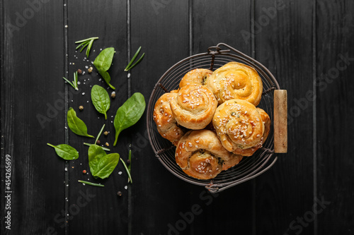 Puff pastry stuffed with spinach on dark wooden background
