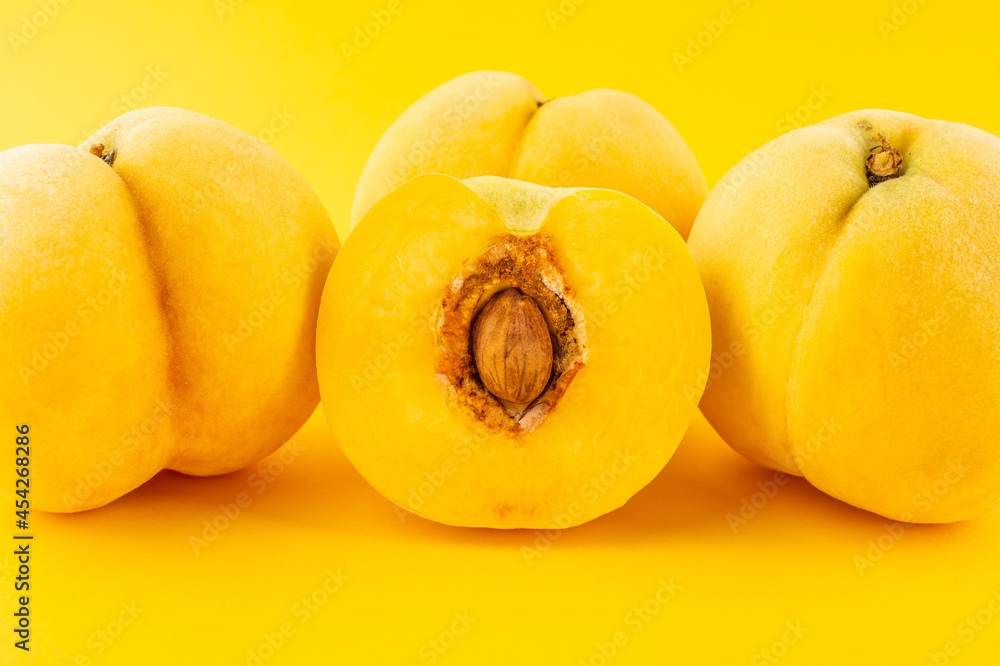 Fresh yellow peaches on yellow background