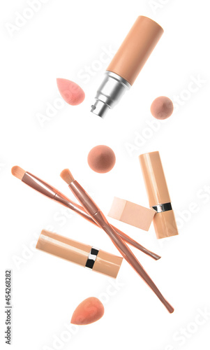 Tonal foundation with makeup brushes and sponges on white background