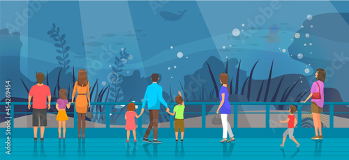People watching underwater scenery with sea animals in oceanarium. Underwater fauna with fish, seaweed, whale, jellyfish. Marine world representatives. Oceanarium visitors look at fish in aquarium