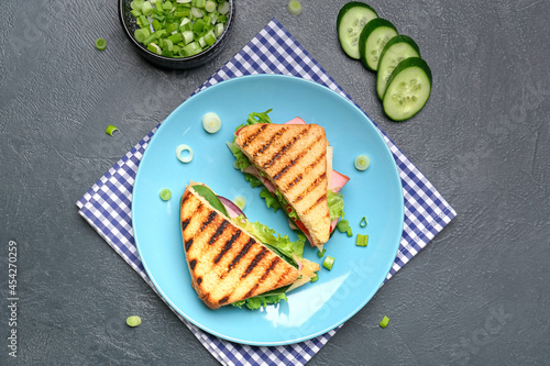 Plate with tasty sandwiches on dark background