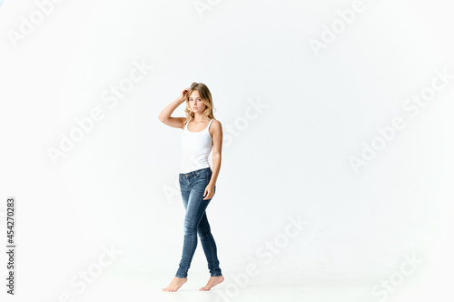 woman barefoot in jeans movement positive emotions light background