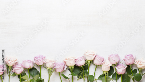 Flowers composition. Frame made of pink rose on gray background. Flat lay, top view, copy space.