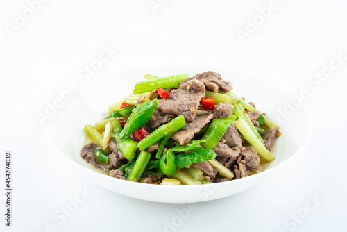 Stir-fried beef with celery on a dish on white background