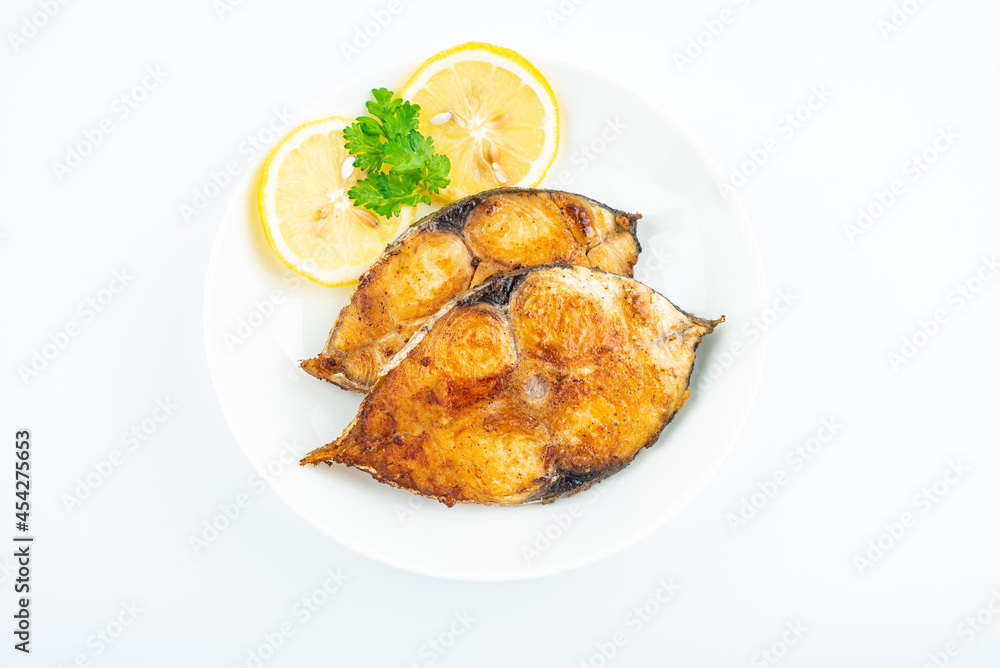 Pan-fried mackerel pieces on a plate on white background Pan-fried mackerel pieces on a plate on white background