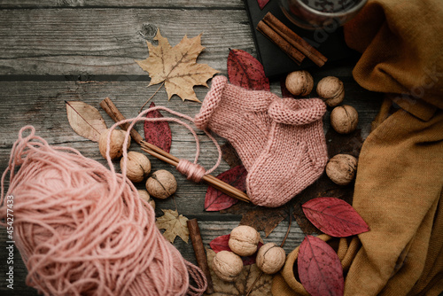 Fototapeta Naklejka Na Ścianę i Meble -  Cute small woolen baby socks, autumn decorations, on dark wooden background