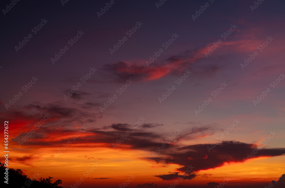 Dramatic red and orange sky and clouds abstract background. Red-orange clouds on sunset sky. Warm weather background. Art picture of the sky at dusk. Sunset abstract background. Dusk and dawn concept.