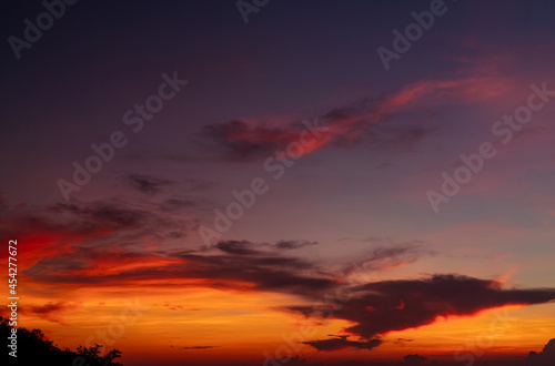 Dramatic red and orange sky and clouds abstract background. Red-orange clouds on sunset sky. Warm weather background. Art picture of the sky at dusk. Sunset abstract background. Dusk and dawn concept.