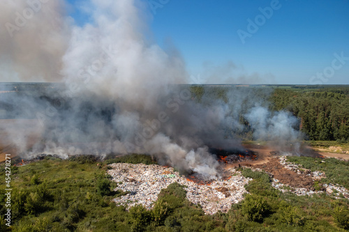 Burning garbage dump at summer. Polluting air with toxic gases
