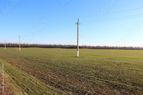 Plowed agricultural field and electric poles in the middle of the field
