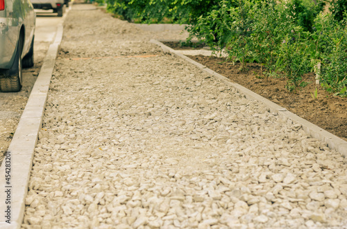 Construction of new sidewalks. Pedestrian walkway fenced with new curbs. Backfilled with crushed stone and compacted. Ready for the next phase. Repair and construction work. Outside. Selective focus