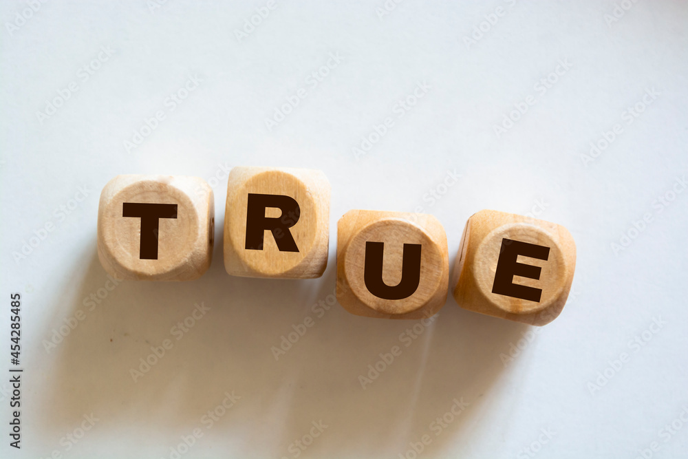 Text TRUE made of wood cubes on white background. Square wood blocks. Top view Text TRUE made of wood cubes on white background. Square wood blocks. Top view