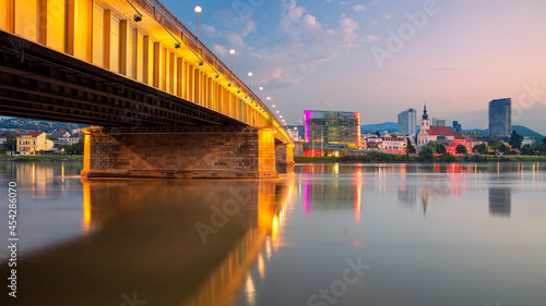 Linz, Austria. Cityscape image of riverside Linz, Austria at summer sunrise with reflection of the city lights in Danube river.