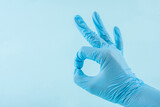 Doctor wearing blue gloves with OK gesture