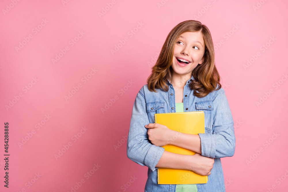 Photo portrait girl smiling keeping copybook looking copyspace isolated pastel pink color background Photo portrait girl smiling keeping copybook looking copyspace isolated pastel pink color background