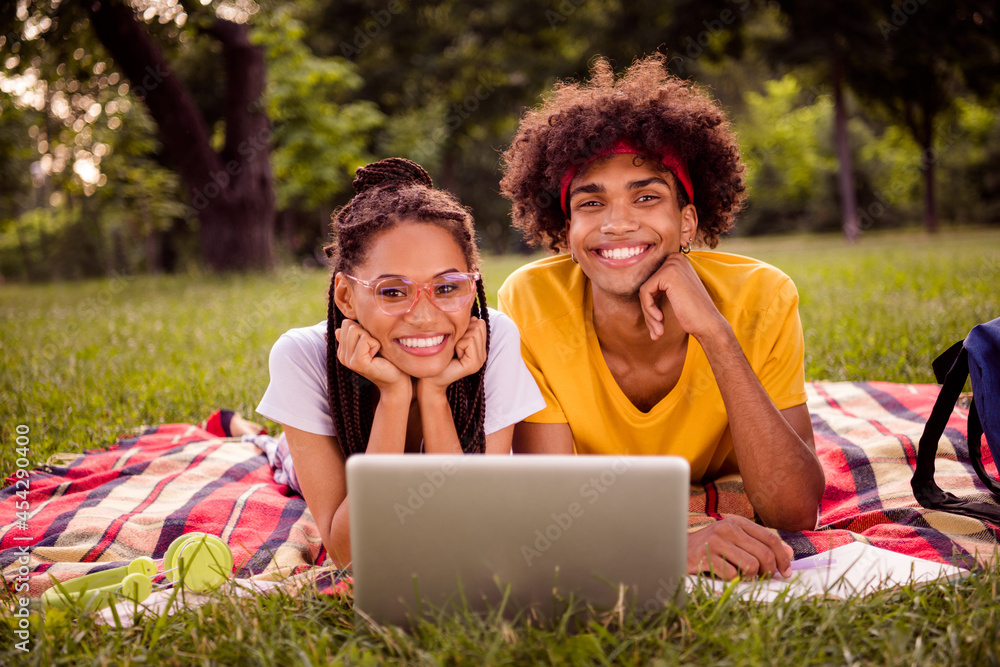 Portrait of handsome beautiful cheerful couple lying on veil watching tutorial video preparing home task weekend at forest outdoors Portrait of handsome beautiful cheerful couple lying on veil watching tutorial video preparing home task weekend at forest outdoors