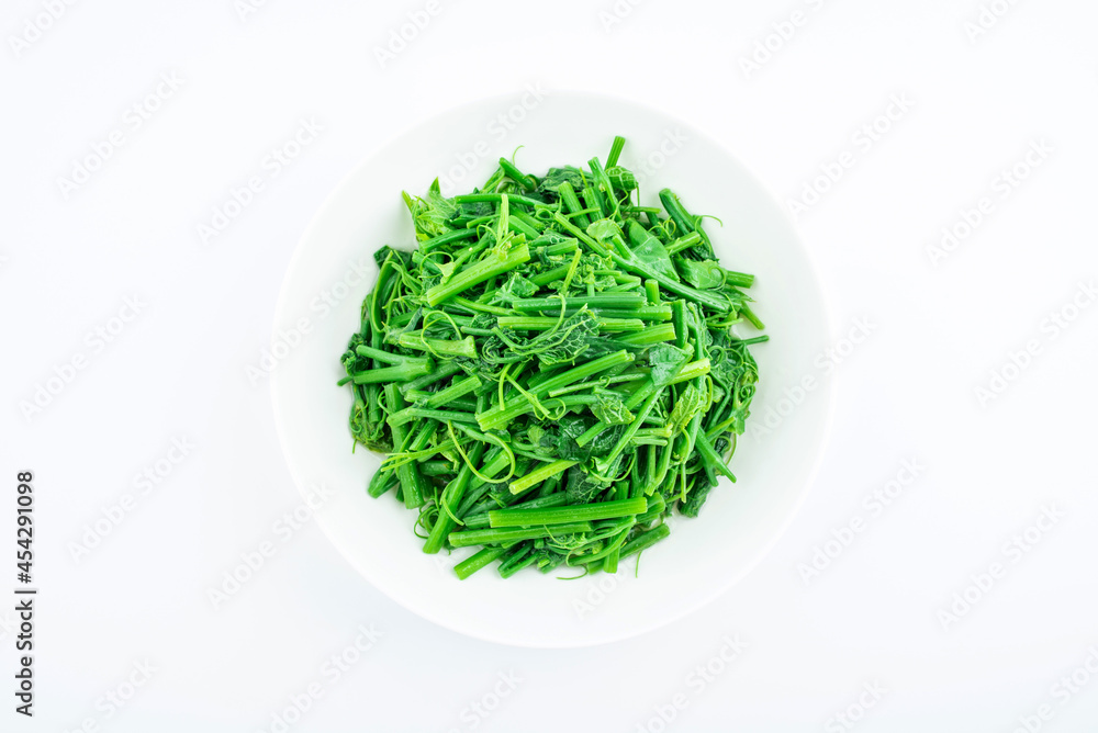 A dish of fried pumpkin vines on white background A dish of fried pumpkin vines on white background