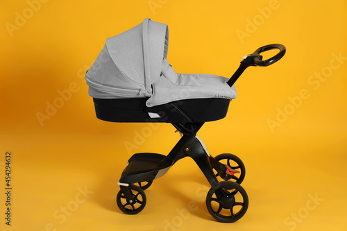 Baby carriage. Modern pram on yellow background