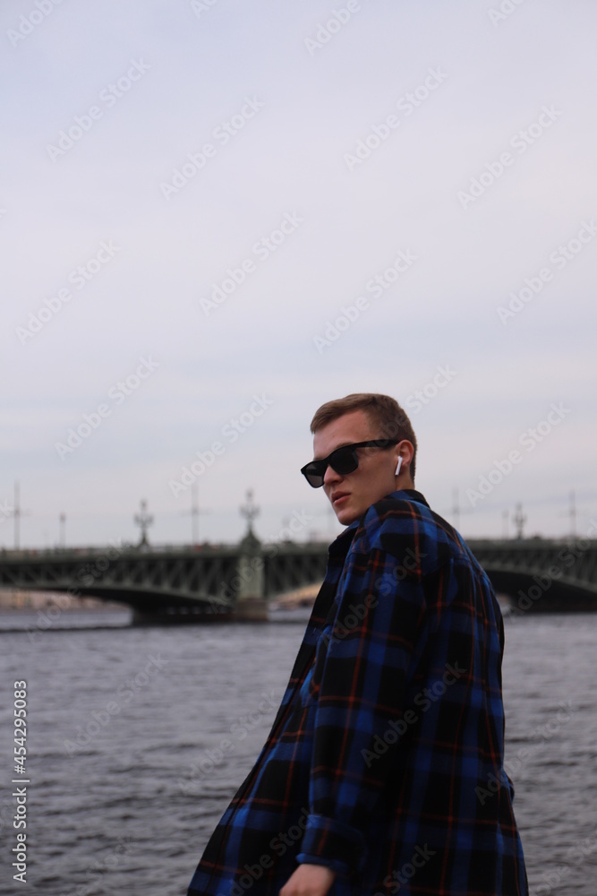 Young man walking on the embankment of Saint-Petersburg's river