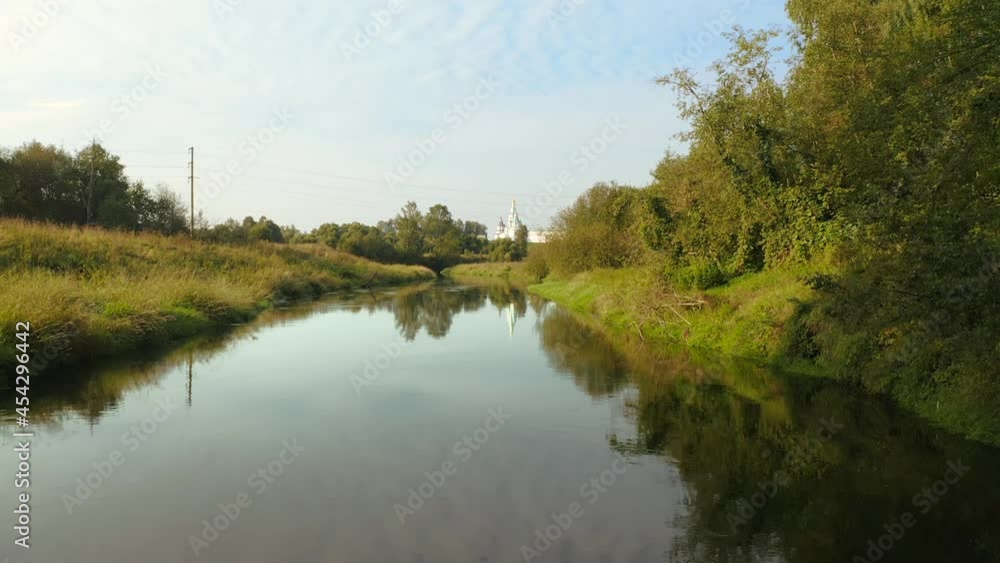 Aerial view close to the land and the river in small rural town with orthodox monastery landmark Aerial view close to the land and the river in small rural town with orthodox monastery landmark