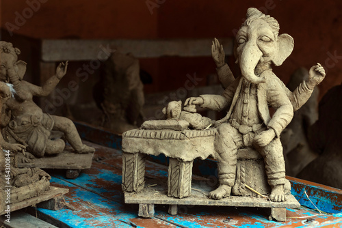 Creative unfinished clay model of Lord Ganesh\Ganesha wherein he is shown as a doctor giving treatment to Dinka the mouse, vehicle of Ganesha,  prepared by local artisans in India photo