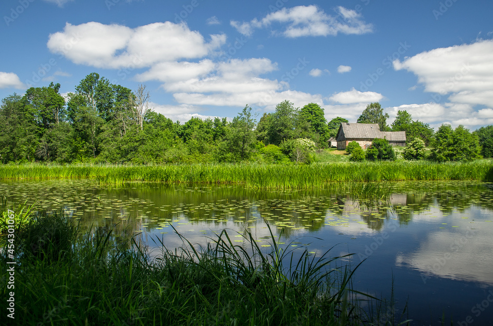 Pond in the summer with house and reflections, Edole, Latvia. Pond in the summer with house and reflections, Edole, Latvia.