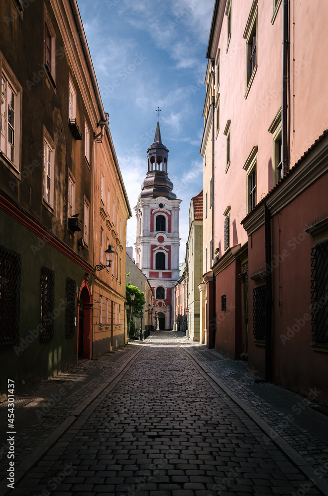 CITYSCAPE - An atmospheric street in Poznan with historic tenement houses and a church 
