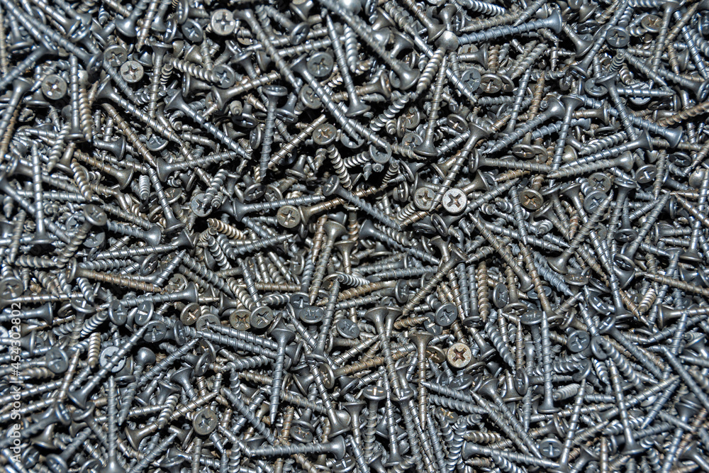 Background of black metal screws, top view, close-up. Purchase of repair tools. Renovation concept. Do it yourself Background of black metal screws, top view, close-up. Purchase of repair tools. Renovation concept. Do it yourself