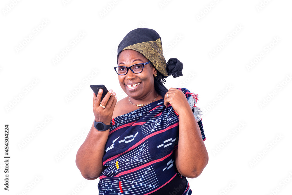 close-up of a beautiful African woman in traditional dress with cellphone, happy. close-up of a beautiful African woman in traditional dress with cellphone, happy.
