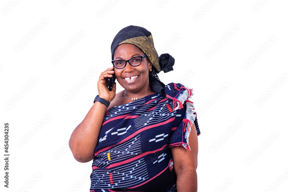Fototapeta premium close-up of a beautiful African woman in traditional dress with cellphone, happy.