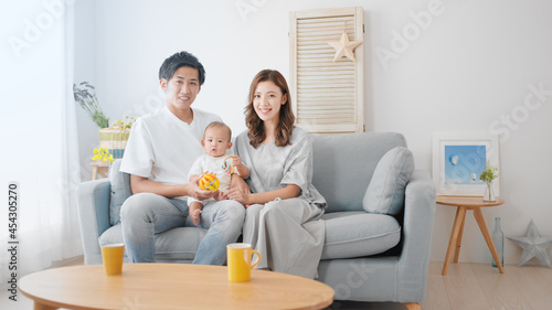 赤ちゃんをあやす両親 © aijiro