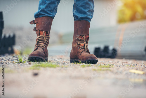 Men wear construction Boots safety footwear for worker at construction site. Engineer Wear Jeans Brown Boots Worker on Background of Refinery. Engineer safety industry fashion footwear walking outdoor
