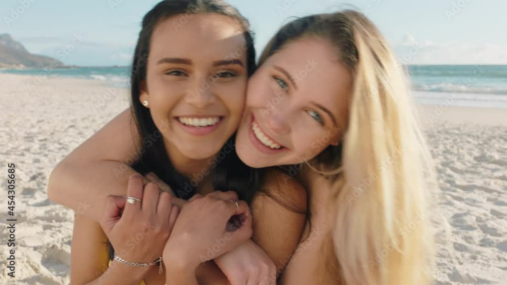 young woman hugging girl friend on beach giving suprise hug best friends having fun summer vacation young woman hugging girl friend on beach giving suprise hug best friends having fun summer vacation