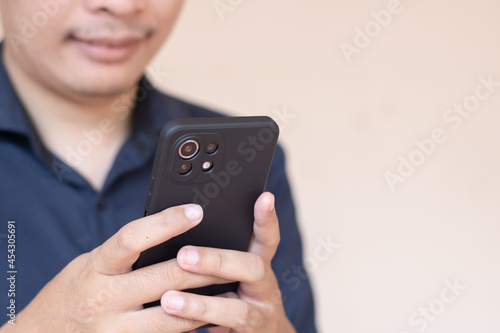 Wallpaper Mural Happy Asian man smile and using or holding smartphone with one hand. Torontodigital.ca