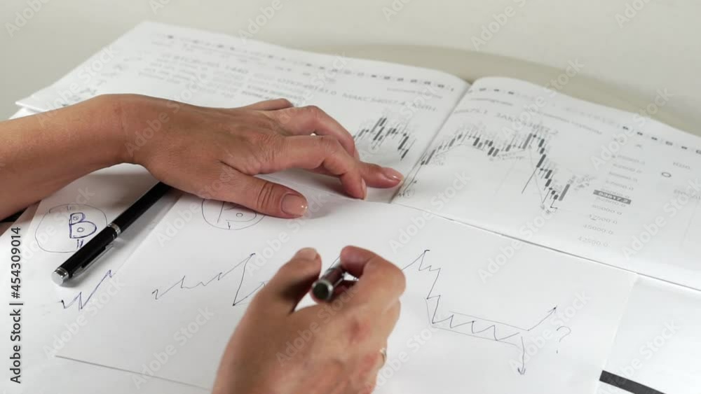 Bitcoin Stock Chart Analysis: A broker, trader or investor is analyzing a cryptocurrency stock chart. Bitcoin Stock Chart Analysis: A broker, trader or investor is analyzing a cryptocurrency stock chart.