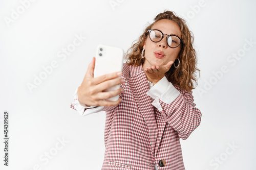 Obraz na plátně Cute female manager taking selfie, sending kisses at mobile phone camera, romatn