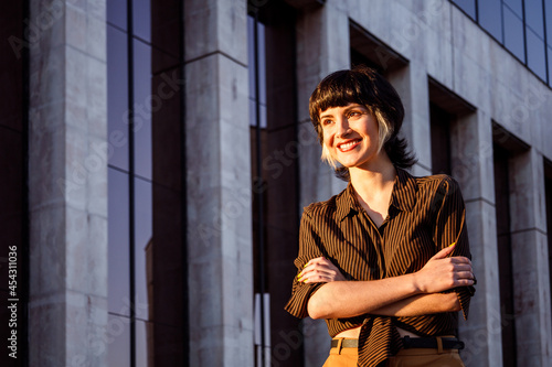 Portrait of young businesswoman with short dyed hair and crossed arms. Copy space. Autumn