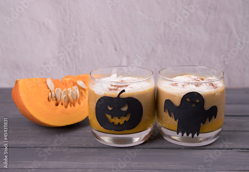 Pumpkin latte in glass glasses and Halloween-themed drawings. Drinks for Halloween