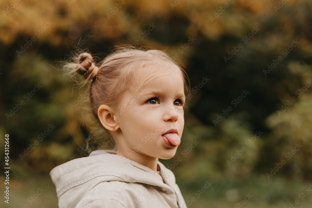 portrait of a girl who grimaces, shows different emotions when walking in the autumn park portrait of a girl who grimaces, shows different emotions when walking in the autumn park