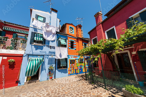 Burano island, houses with bright colors and clothes hanging on clotheslines to dry in the sun. House of Bepi, Venetian lagoon, Venice, UNESCO world heritage site, Veneto, Italy, Europe.
