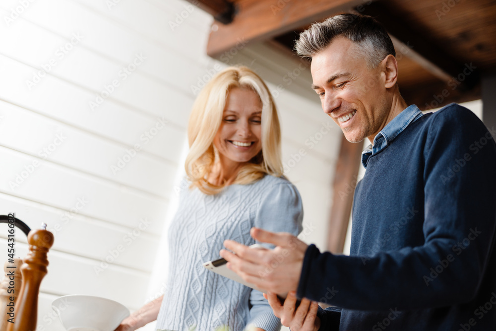 Happy mid whute couple websurfing with tablet Happy mid whute couple websurfing with tablet