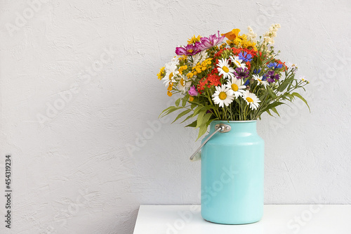 Bouquet of bright flowers in tin can vase on background grey stone wall Fototapet