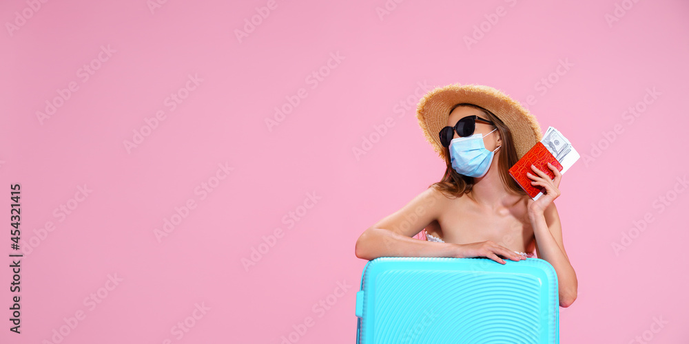 Young woman waiting for flight, sitting on floor near her suitcase, wearing face mask to prevent coronavirus Young woman waiting for flight, sitting on floor near her suitcase, wearing face mask to prevent coronavirus