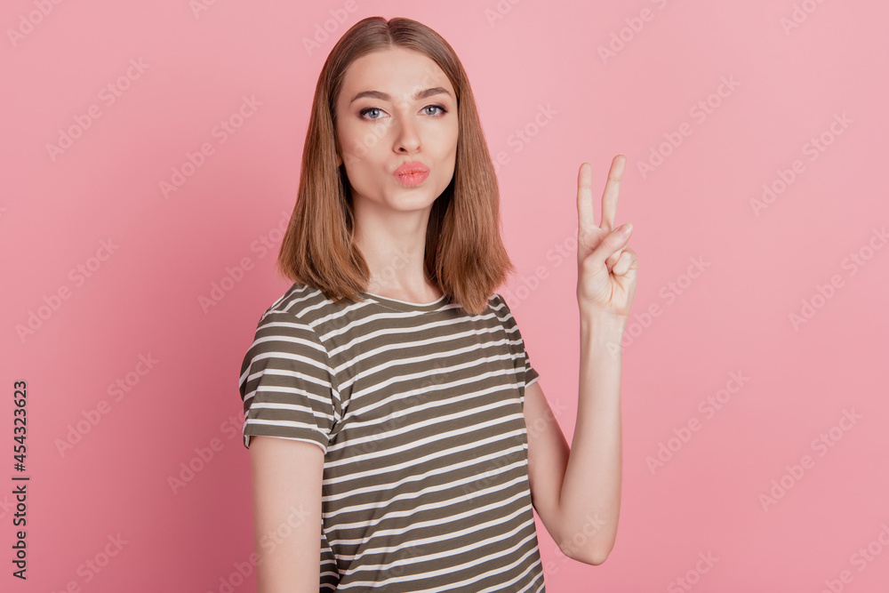 Portrait of charming affectionate flirty lady show v-sign send air kiss on pink background Portrait of charming affectionate flirty lady show v-sign send air kiss on pink background