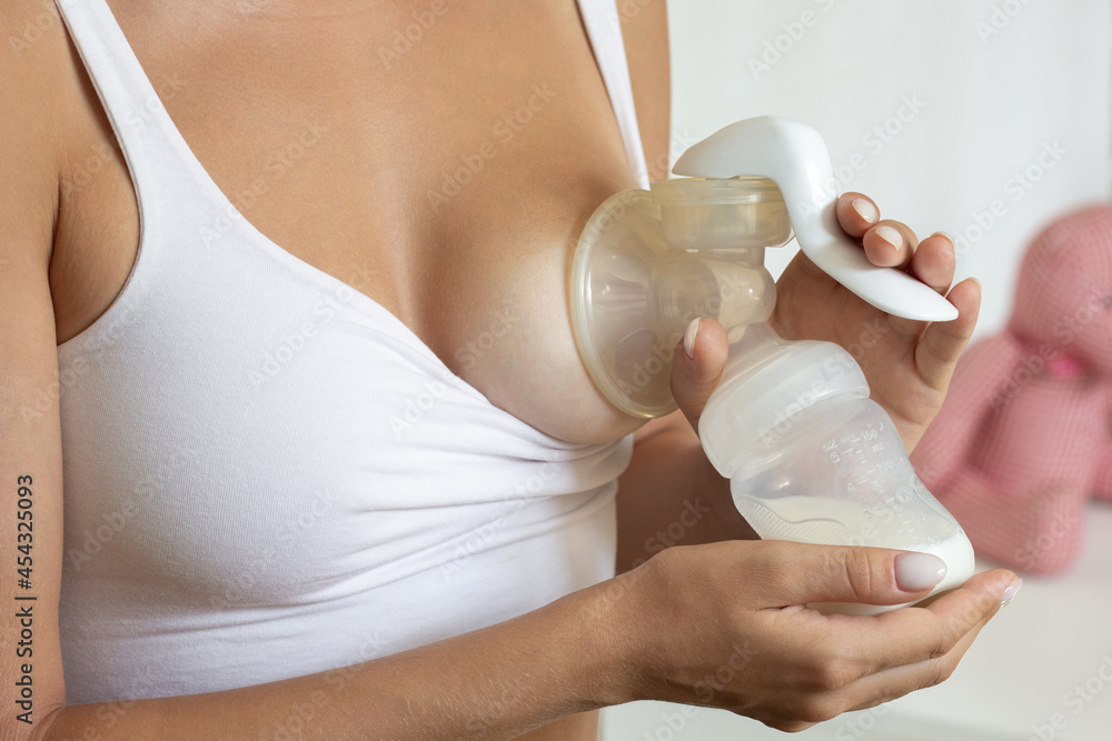 Woman hands holding manual breast pump for expressing milk for feeding baby Woman hands holding manual breast pump for expressing milk for feeding baby