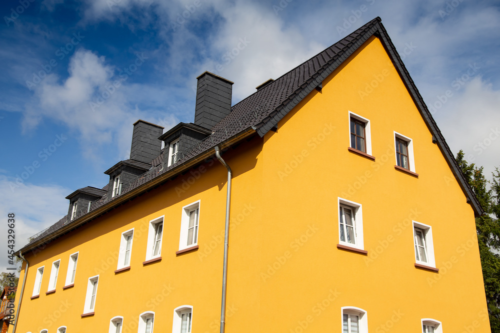 Renovierter Altbau mit neuem gelbem Fassadenanstrich Renovierter Altbau mit neuem gelbem Fassadenanstrich