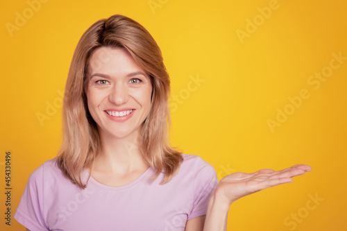 Wallpaper Mural Portrait of positive adviser lady hand show empty space promoting object on yellow background Torontodigital.ca