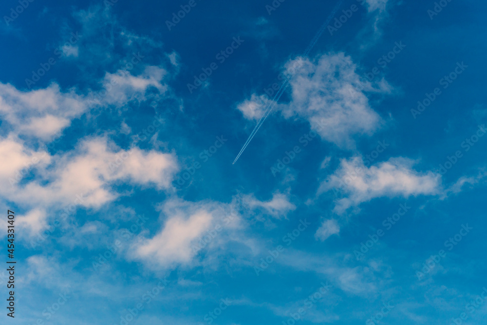 Airplane flying in the blue sky among clouds and sunlight
Airplane flying in the blue sky among clouds and sunlight