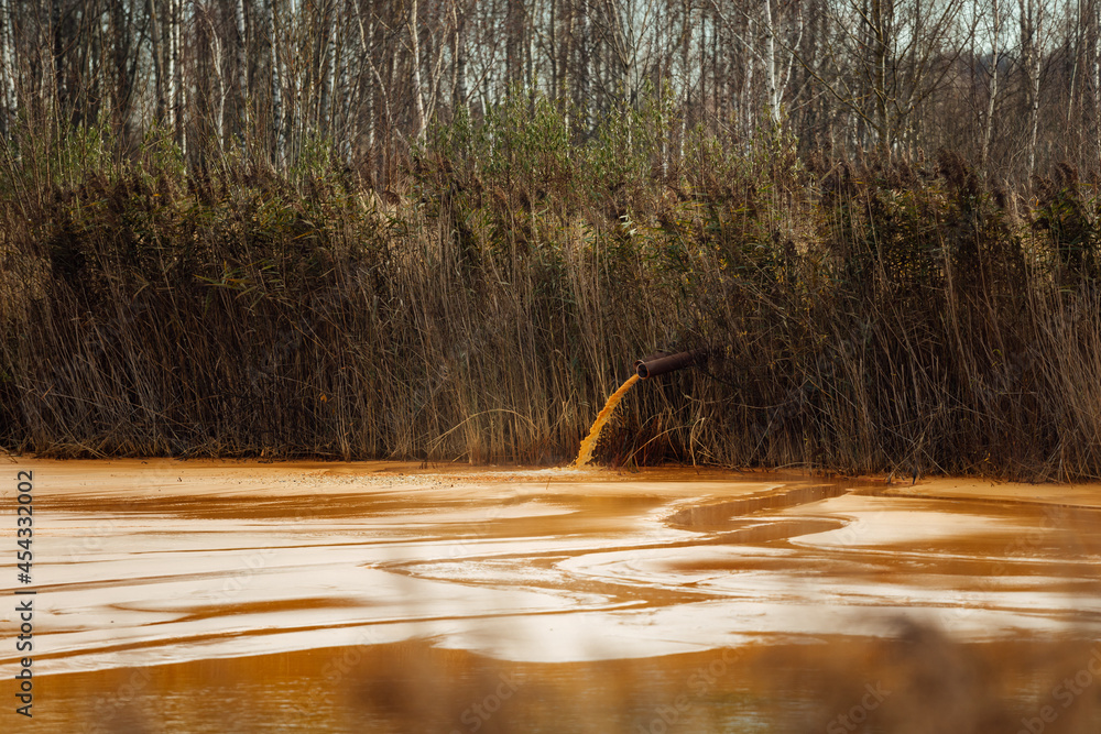 Foto de the pipe discharges waste into the water. contamination of the